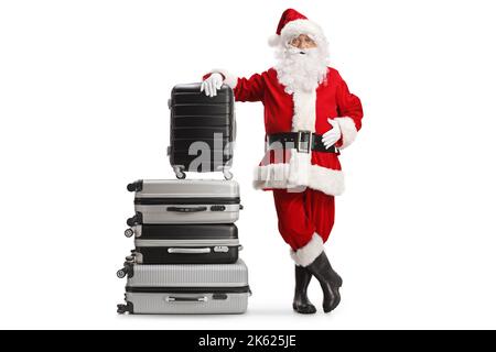 Santa claus leaning on a pile of suitcases isolated on white background Stock Photo