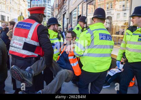 London, UK. 11th Oct, 2022. Police officers arrest a Just Stop Oil activist who was glued to the road and blocked Brompton Road in Knightsbridge during the protest. The climate action group continues its daily protests demanding that the UK Government stops issuing new oil and gas licenses. (Photo by Vuk Valcic/SOPA Images/Sipa USA) Credit: Sipa USA/Alamy Live News Stock Photo