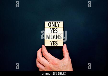 Only yes means yes symbol. Concept words Only yes means yes on wooden blocks on a beautiful black table black background. Businessman hand. Business, Stock Photo