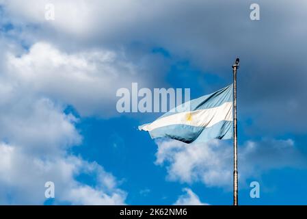 Argentine flag flying on a flagpole against a cloudy sky. Patriotic emblem of Argentina Stock Photo