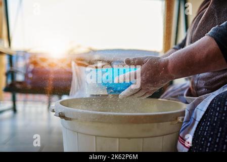 A closeup of a woman's hands sifting flour with flour filter Stock Photo