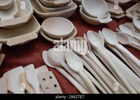 Shallow depth of field (selective focus) details with Romanian traditional hand crafted wooden kitchen utensils (bowls, spatulas, forks, spoons). Stock Photo