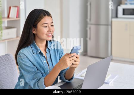 Young asian woman freelancer using mobile phone app for online video call Stock Photo