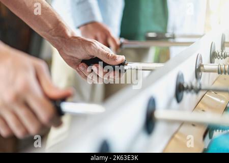 People Playing Enjoying Foosball Table Soccer Game closeup on hands Stock Photo