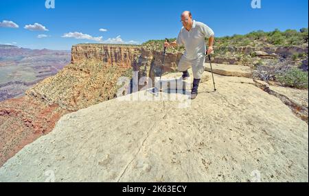 A hiker on the edge of a cliff between Moran Point and Zuni Point at Grand Canyon Arizona. Stock Photo
