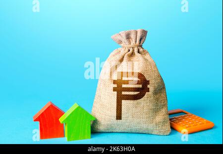 Philippine peso money bag and small houses. Bank offer of mortgage loan. Property appraisal, realtor services. Investments in real estate. Sale of hou Stock Photo