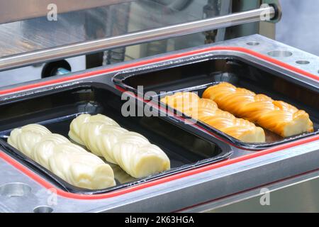 Linear food cheese smoked plastic tray package heat sealing machine. Food industry concept background Stock Photo