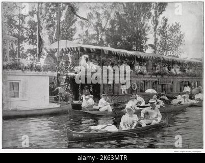 Along the banks of the River Thames ranged rows of house-boats, floating villas, crowded with gaily-dressed spectators, during the Henley Regatta. Stock Photo