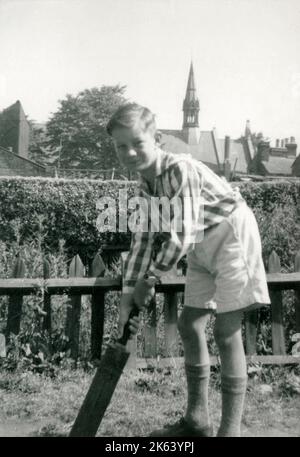 A Young boy playing cricket in a suburban garden - he awaits for a delivery to arrive... Stock Photo