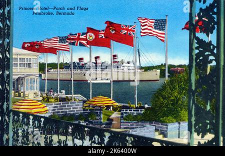 The United States, British and Bermuda flags on The Princess Hotel Terrace flay in honour of the outward-bound SS Queen of Bermuda. Stock Photo