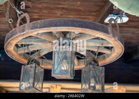 An old and rusty chandelier of hanging lamps on a porch Stock Photo