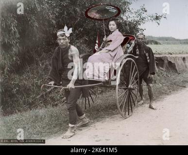 Young woman being pulled in a rickshaw jinrikisha. Vintage 19th century photograph. Stock Photo