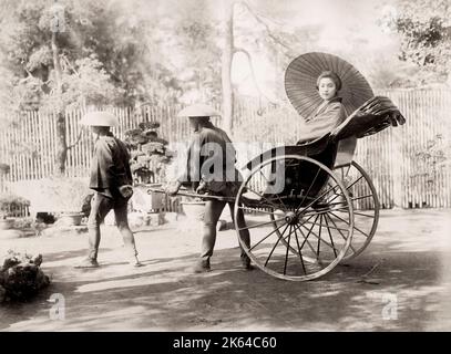 Vintage 19th century photograph: young woman in a rickshaw, jinrikisha, Japan. Stock Photo