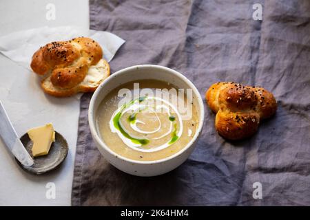 Creamy celeriac soup with parssley oil and black onion seeds Stock Photo
