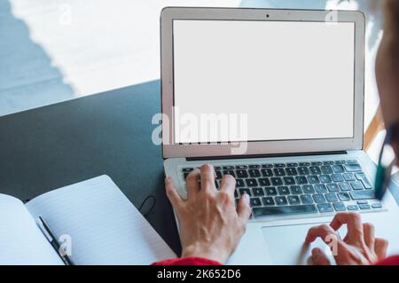 rear view close up of young caucasian woman working watching laptop screen and typing her company data, sitting in restaurant, business concept with c Stock Photo
