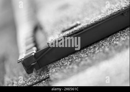 Ridge cap vent installed on a shingle roof for passive attic ventilation on a residential house.  Stock Photo