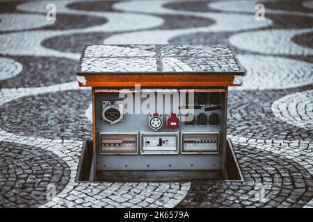 An outdoor underground retractable switchboard with multiple power outlets of different types and power capacities, rows of toggle switches, and butto Stock Photo