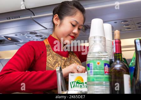 Flight crew and passengers on board Vietnam Airlines flight from Hanoi to Bangkok Stock Photo