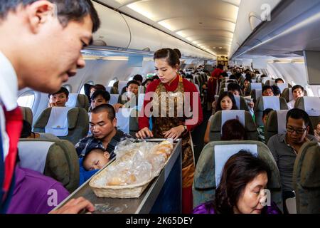 Flight crew and passengers on board Vietnam Airlines flight from Hanoi to Bangkok Stock Photo