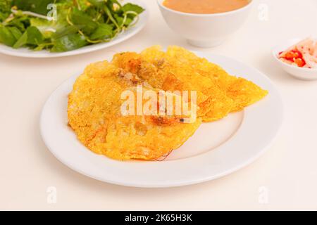 Banh xeo, Vietnamese Crêpes or Pancakes with pork, shrimp, onions, beasn sprouts inside and fish sauce. Vietnamese food isolated on white background; Stock Photo