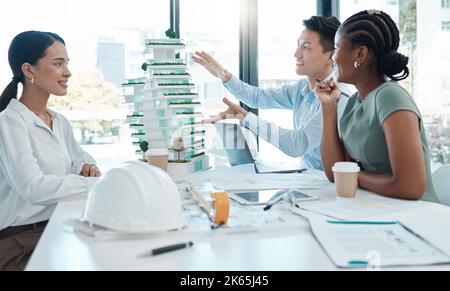 Model, construction and architects planning a building project together in an office at work. Creative, corporate and architecture workers talking Stock Photo
