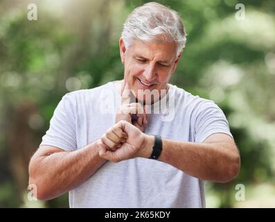 Counting is pulse rate by hand. a mature man using a watch and checking his pulse while exercising outdoors. Stock Photo