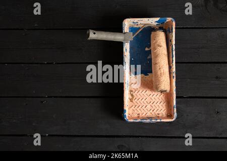 paint roller in paint tray on black wooden floor, painting, paint roller, repair, paint Stock Photo