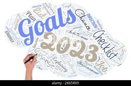 Big word cloud in the shape of UFO with hand and pen with words goals 2023. Identifying something you want to accomplish. Expectations Stock Photo