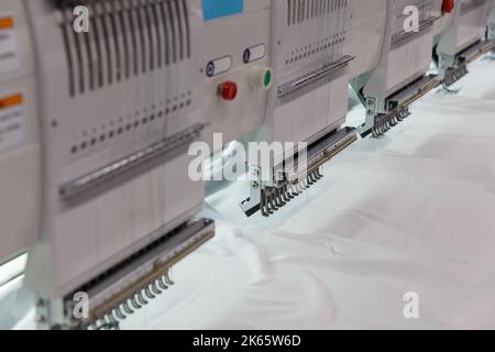 Machine embroidery is an embroidery process whereby a sewing machine or embroidery machine is used to create patterns on textiles. Textile: Industrial Stock Photo