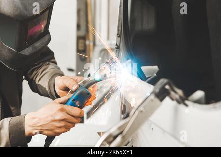 Metal working car body with carbon dioxide welding machine. Repair of vehicle in service to restore after the accident. Stock Photo