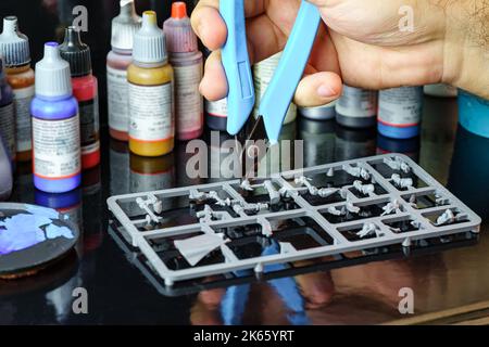 Small figures and parts used for role-playing games, separated by small pliers Stock Photo