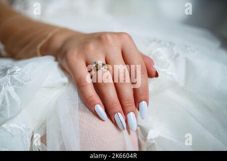 The bride's golden wedding ring on her finger on her wedding day Stock Photo