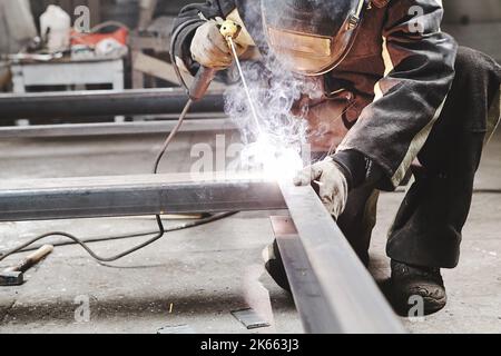 Male in face mask welds with welding Stock Photo