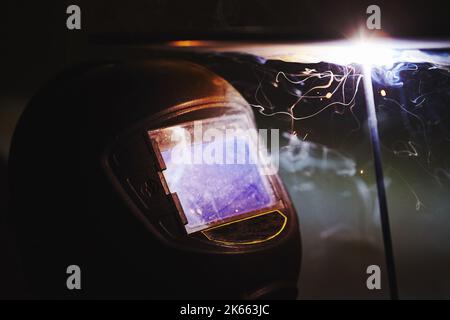 Man in protective mask welding metal construction. Stock Photo