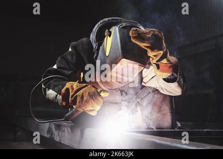 Male in face mask welds with welding Stock Photo