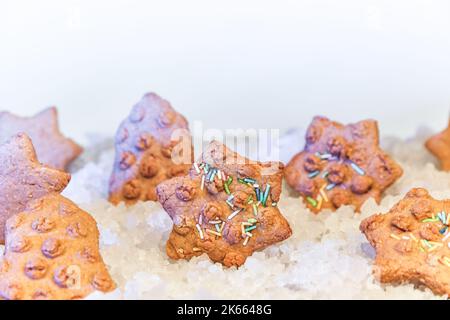 Christmas gingerbread cookies in the form of a star in decorative snow and ice on a blurred background with holiday baking Stock Photo