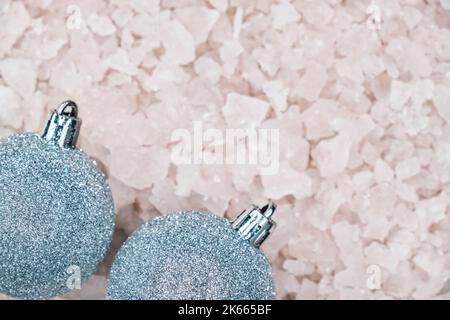 Top view of Christmas decorative silver blue balls on blurred background of ice pieces with copy space for greeting text. Stock Photo