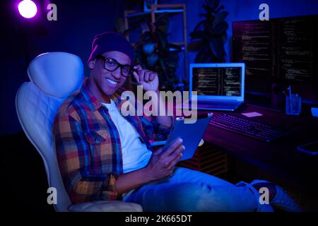 Profile photo of positive hacker sit chair use tablet operating research evening loft office business centre Stock Photo