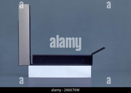 A long, thin rectangular box with the silver-grey lid open, revealing the velvety blue of the empty interior. Gifts and packaging. Stock Photo