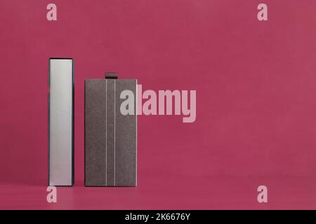 A long thin rectangular box with a silver gray lid next to a vintage textured rectangular cardboard box with two thin white lines down the center on a Stock Photo