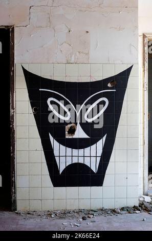 graffiti face on tiled wall in deserted building, puglia, italy Stock Photo