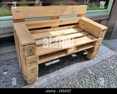 bench made from pallets in front of a downtown store, Germany Stock Photo