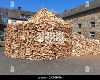 piled up beech firewood in front of a farm, Germany Stock Photo