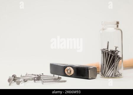 hammer nails and glass jar on table, white background Stock Photo