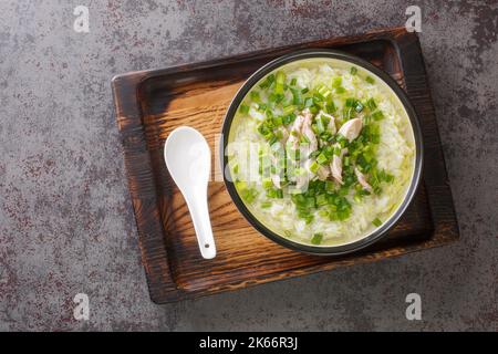 Spicy hot Korean chicken soup with rice and green onions close-up in a bowl on the table. Horizontal top view from above Stock Photo