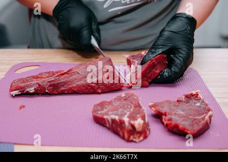 Preparation of raw meat roll. Cooking steaks and meat rolls in the cooking class. Sliced meat on a plate, close-up. Stock Photo