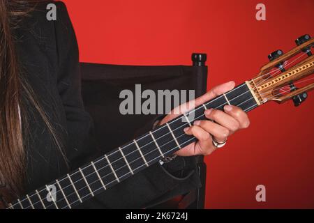 Closeup Young woman playing a CUATRO, typical Venezuelan instrument. Recording session, Concept of music and typical instruments. Stock Photo