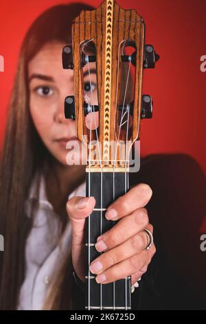 Beautiful young woman playing a CUATRO, typical Venezuelan instrument. Recording session, Concept of music and typical instruments. Stock Photo