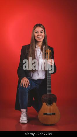 Beautiful young woman playing a CUATRO, typical Venezuelan instrument. Recording session, Concept of music and typical instruments. Stock Photo