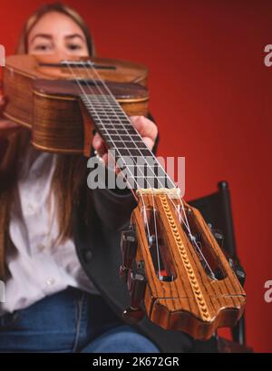 Closeup Young woman playing a CUATRO, typical Venezuelan instrument. Recording session, Concept of music and typical instruments. Stock Photo